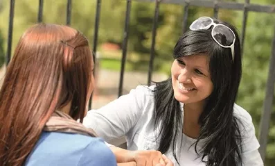 woman talking to teenage girl outdoors